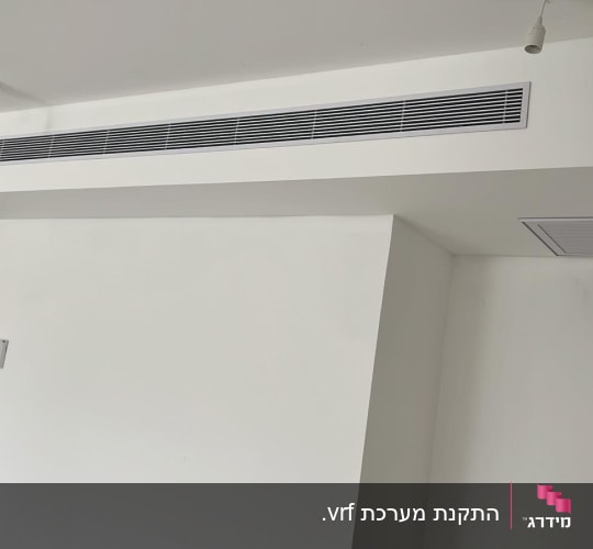 פתחי אוורור של מערכת מיזוג אוויר בתקרה לבנה